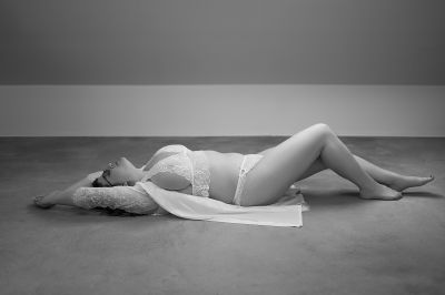 Sinnliches Dessousfoto einer jungen Frau auf dem Boden